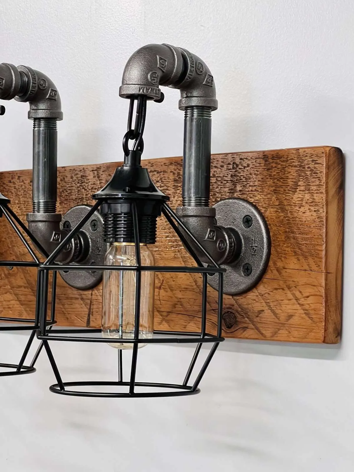 Close up reclaimed wood grain on rustic industrial vanity light fixture