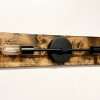 Handmade black metal and wood wall sconce above bathroom mirror