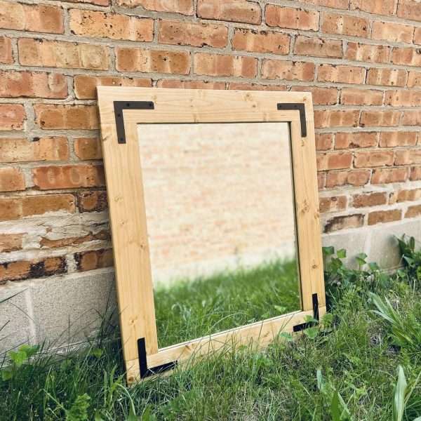 Mirror leaning against brick wall