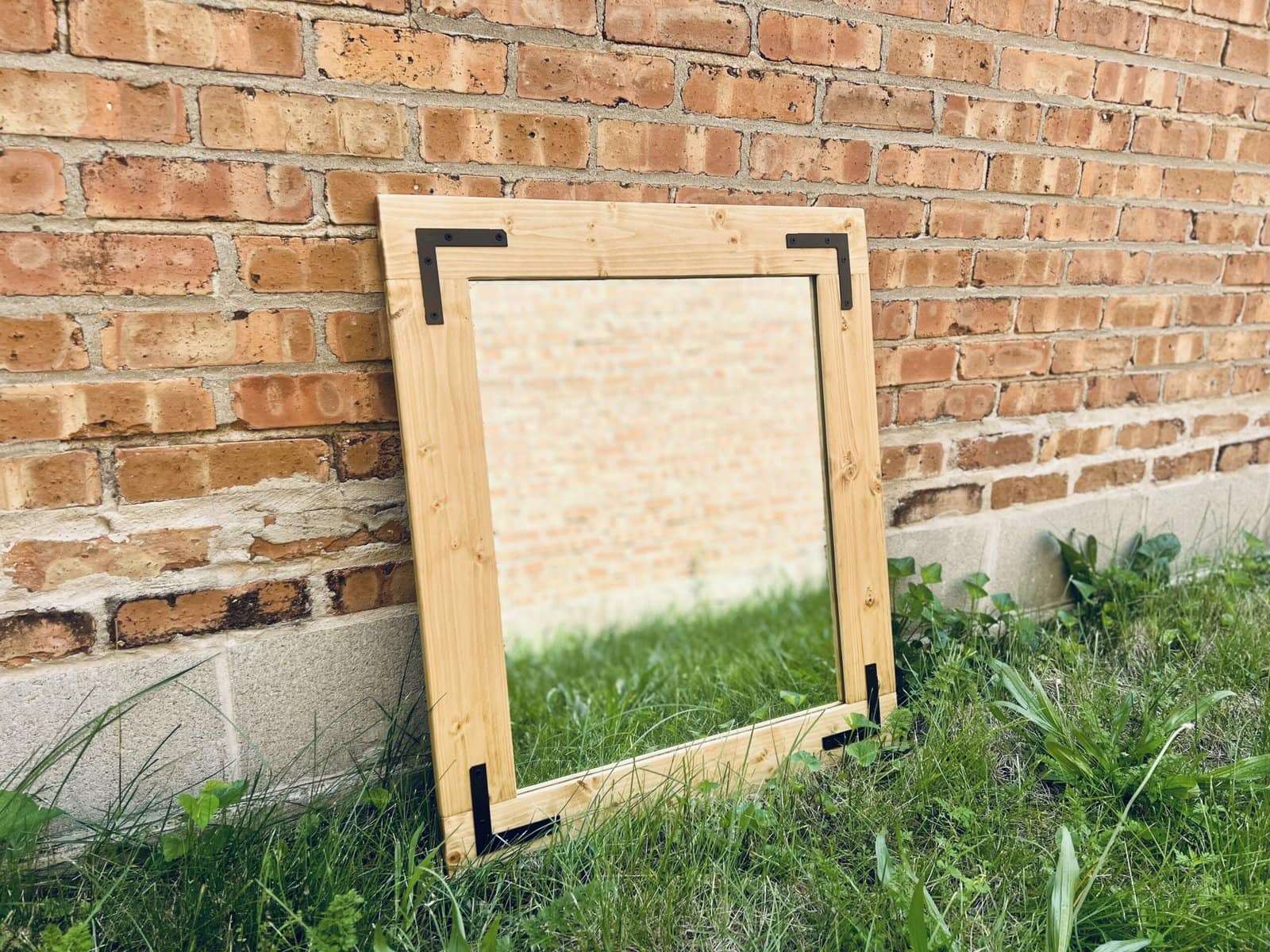 Mirror leaning against brick wall