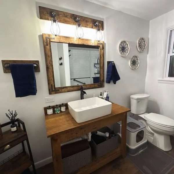 Farmhouse vanity mirror with rustic wood frame and mason cage lighting