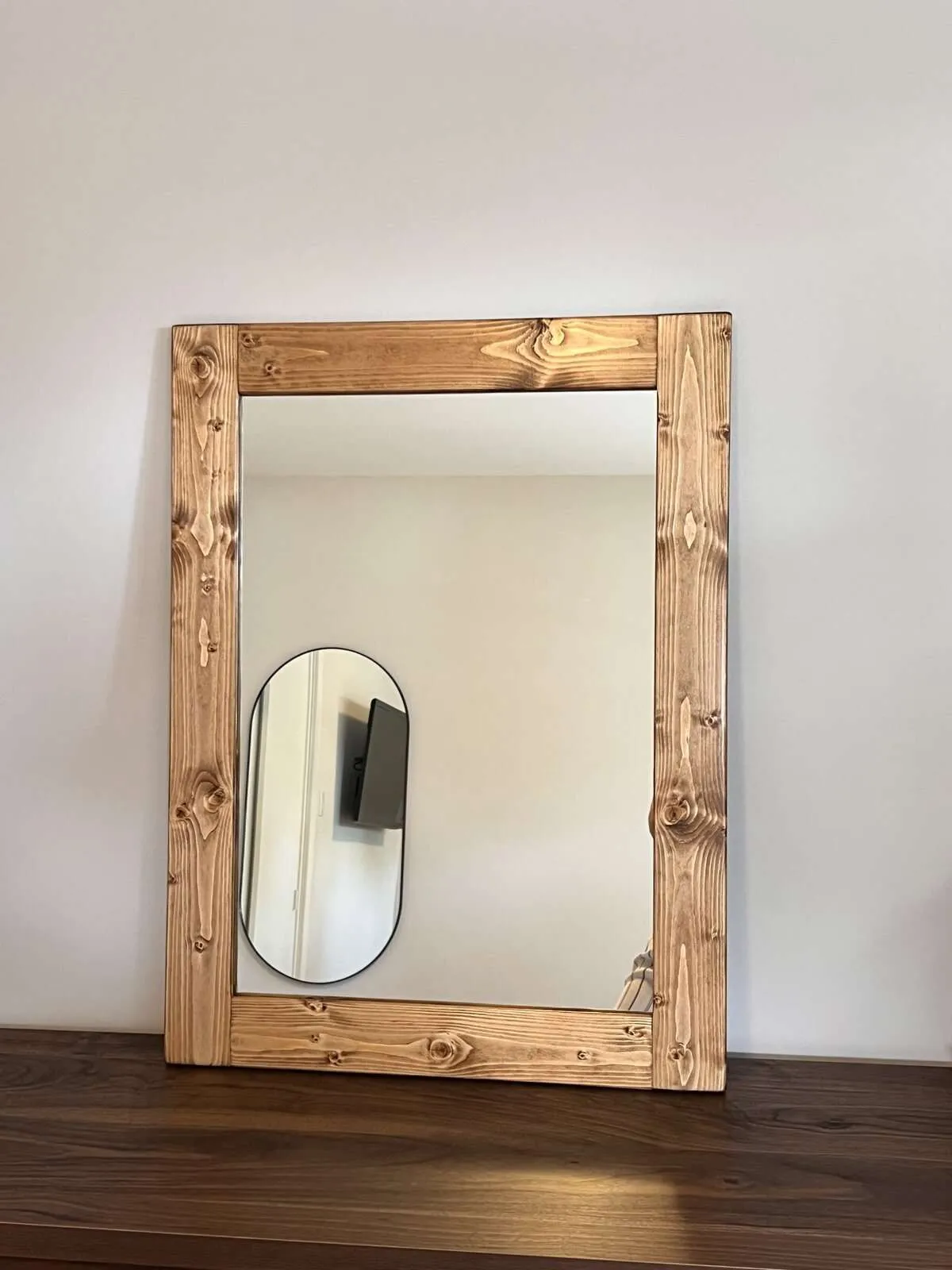 Wooden framed mirror on wall