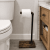 toilet paper stand for one roll sitting next to the toilet on bathroom floor