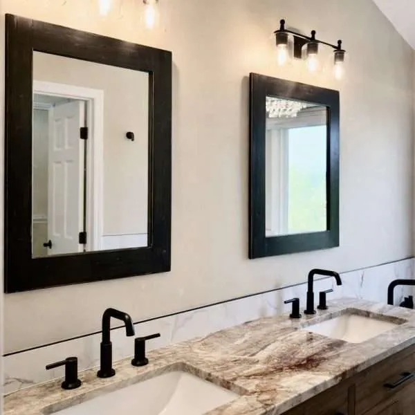 Handmade black farmhouse mirror hanging on wall in modern rustic bathroom