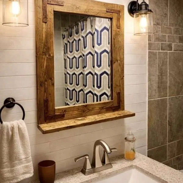 Modern farmhouse bathroom setting with espresso wood framed mirror and shelf